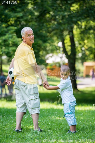 Image of grandfather and child have fun  in park