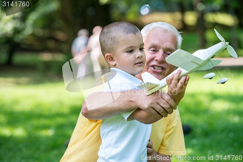 Image of grandfather and child have fun  in park