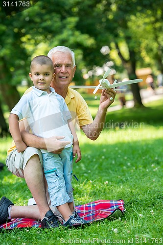 Image of grandfather and child have fun  in park