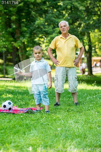 Image of grandfather and child have fun  in park