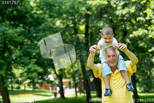 Image of grandfather and child have fun  in park