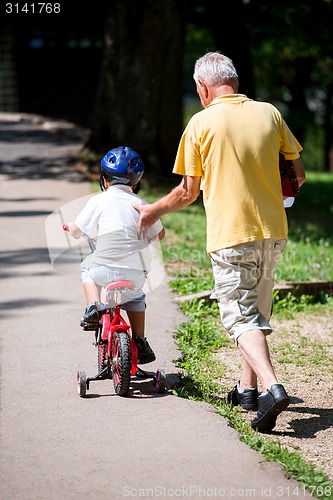 Image of grandfather and child have fun  in park