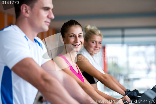 Image of friends  exercising on a treadmill at the bright modern gym