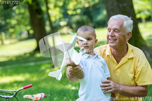 Image of grandfather and child have fun  in park