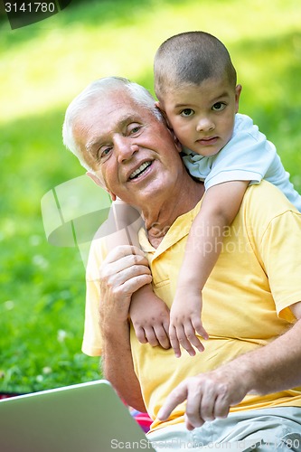 Image of grandfather and child using laptop