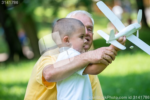 Image of grandfather and child have fun  in park