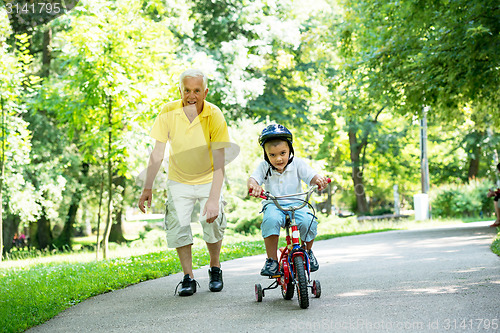 Image of grandfather and child have fun  in park