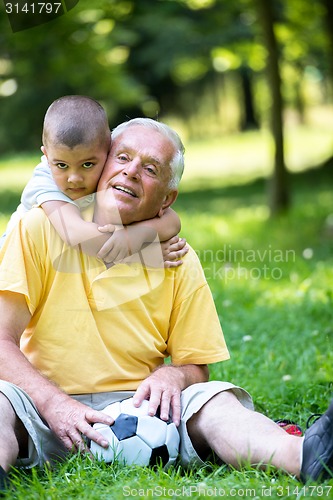 Image of grandfather and child have fun  in park
