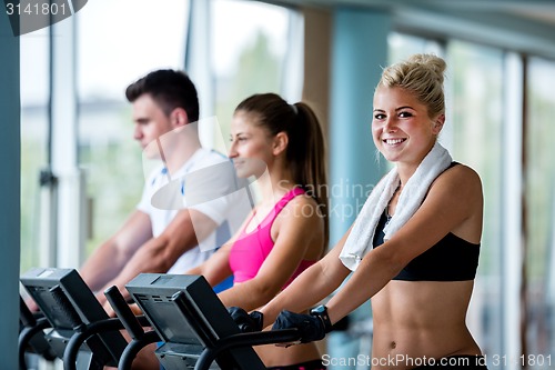 Image of friends  exercising on a treadmill at the bright modern gym