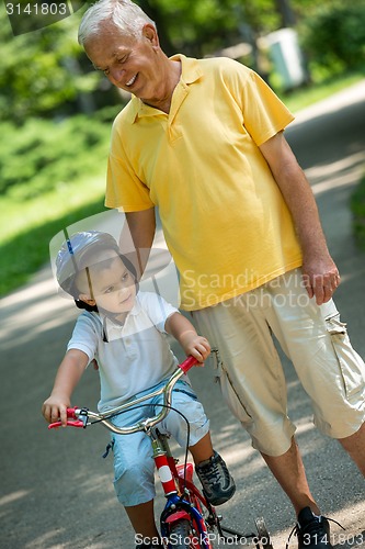 Image of grandfather and child have fun  in park