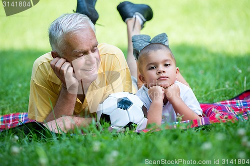 Image of grandfather and child have fun  in park