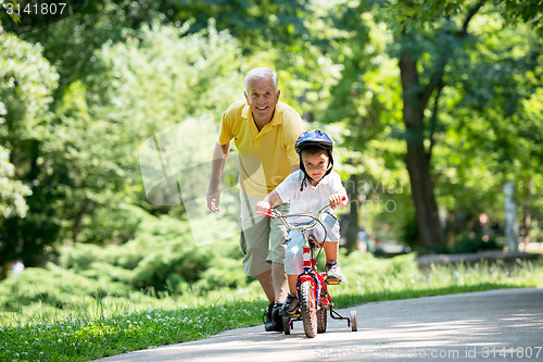 Image of grandfather and child have fun  in park