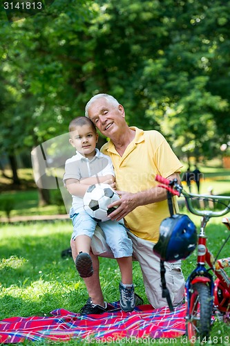 Image of grandfather and child have fun  in park