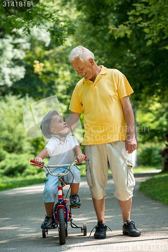 Image of grandfather and child have fun  in park