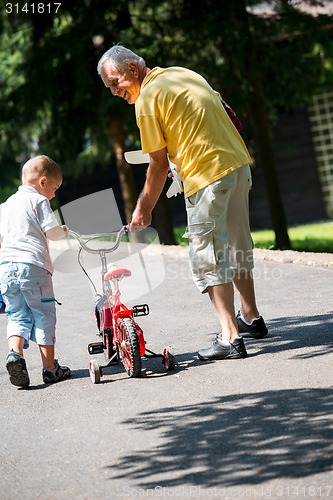 Image of grandfather and child have fun  in park