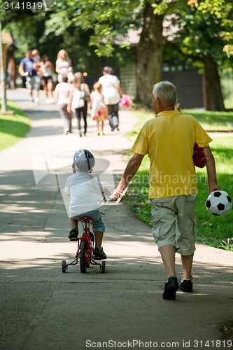 Image of grandfather and child have fun  in park