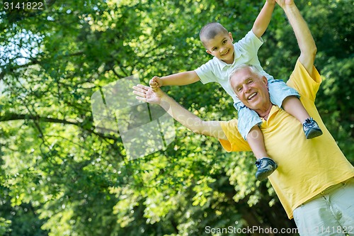 Image of grandfather and child have fun  in park