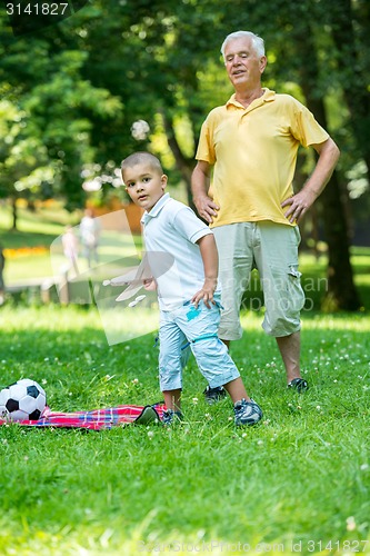 Image of grandfather and child have fun  in park