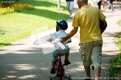 Image of grandfather and child have fun  in park