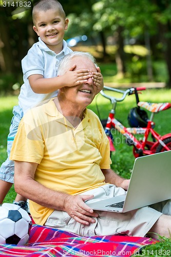 Image of grandfather and child using laptop