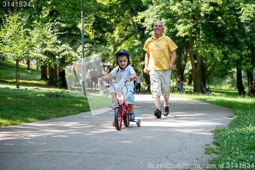 Image of grandfather and child have fun  in park