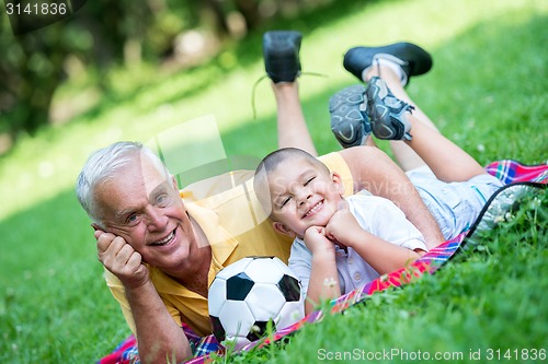 Image of grandfather and child have fun  in park