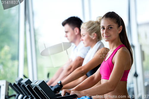 Image of friends  exercising on a treadmill at the bright modern gym