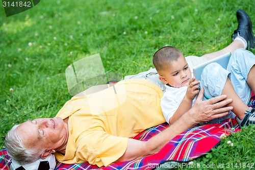 Image of grandfather and child have fun  in park