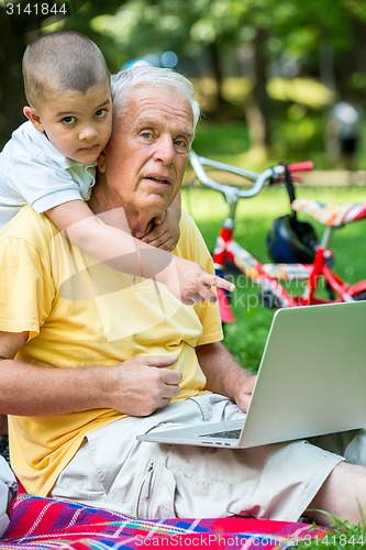 Image of grandfather and child using laptop