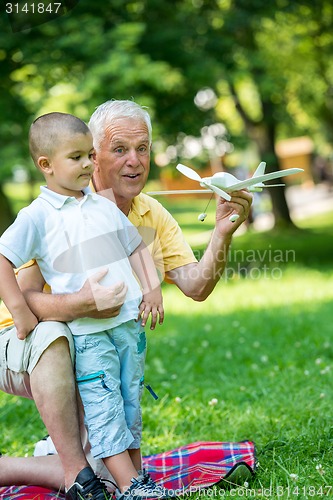 Image of grandfather and child have fun  in park