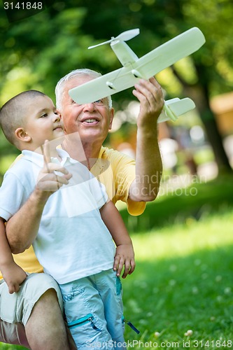 Image of grandfather and child have fun  in park