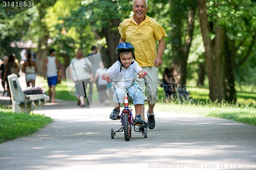 Image of grandfather and child have fun  in park