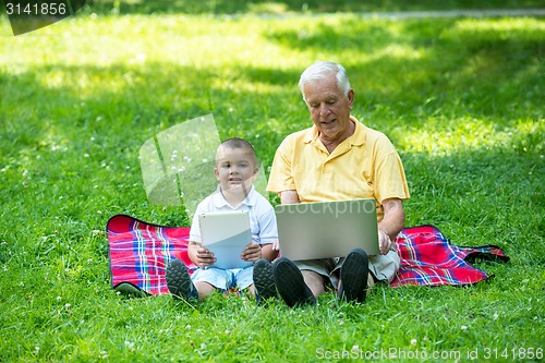 Image of grandfather and child using laptop