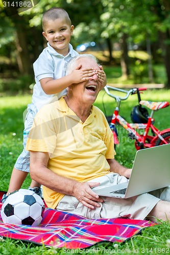 Image of grandfather and child using laptop