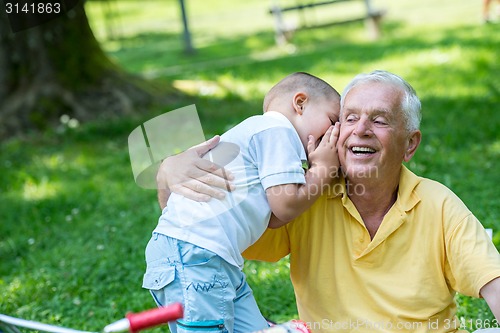 Image of grandfather and child have fun  in park