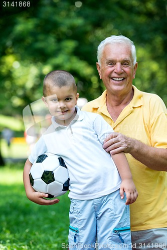 Image of grandfather and child have fun  in park