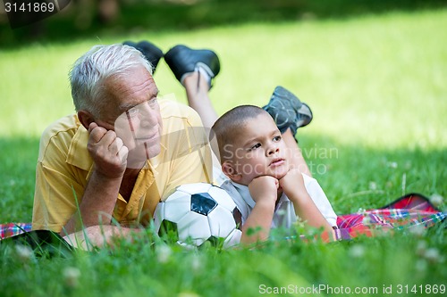 Image of grandfather and child have fun  in park