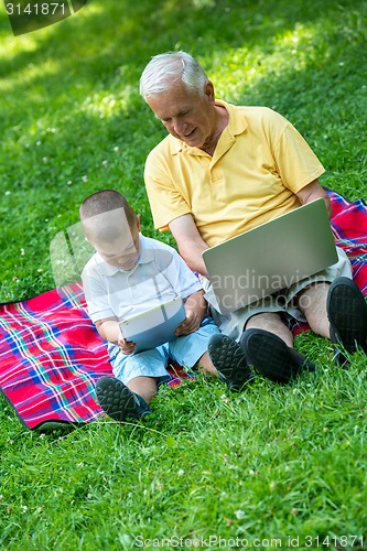 Image of grandfather and child using laptop