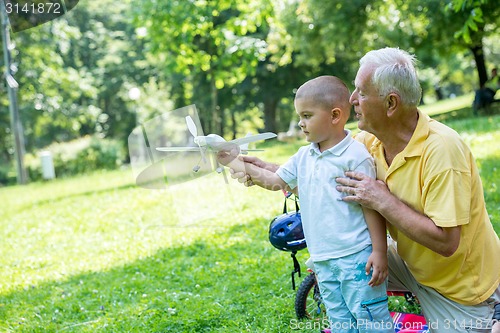 Image of grandfather and child have fun  in park