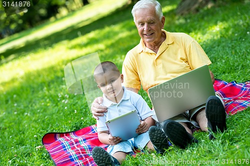 Image of grandfather and child using laptop