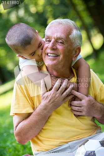 Image of grandfather and child have fun  in park