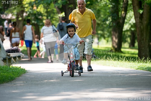 Image of grandfather and child have fun  in park