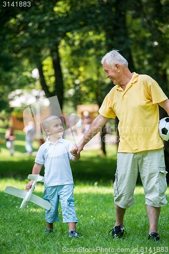 Image of grandfather and child have fun  in park