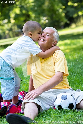 Image of grandfather and child have fun  in park