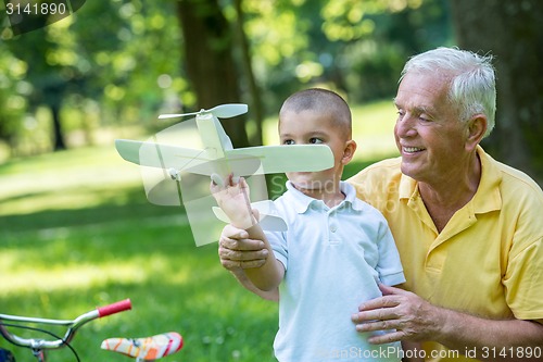 Image of grandfather and child have fun  in park
