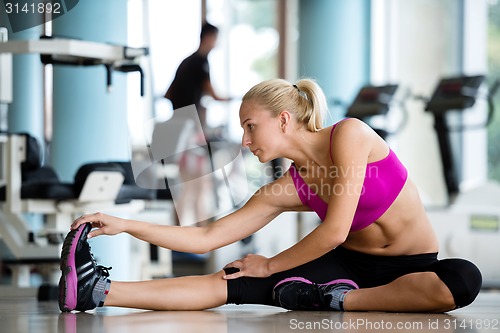 Image of woman stretching and warming up for her training at a gym