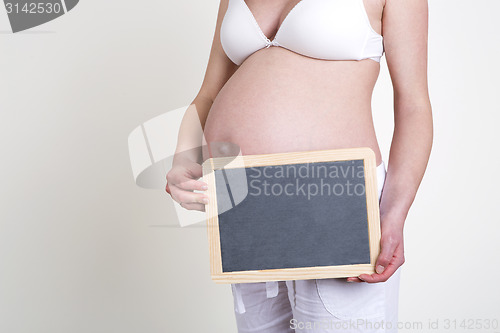 Image of Pregnant woman with an empty blackboard