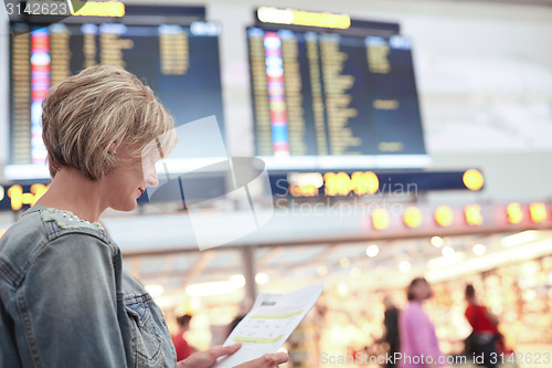 Image of Woman tourist looking at timetable in airport