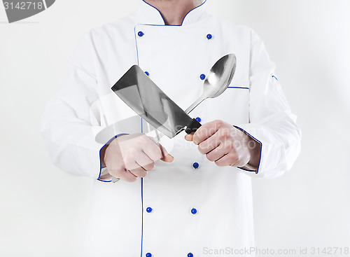 Image of Cook holding hatchet and spoon