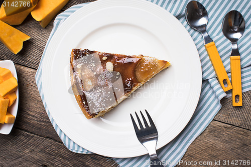 Image of pieces of pie and cut pumpkin on table in Rustic style
